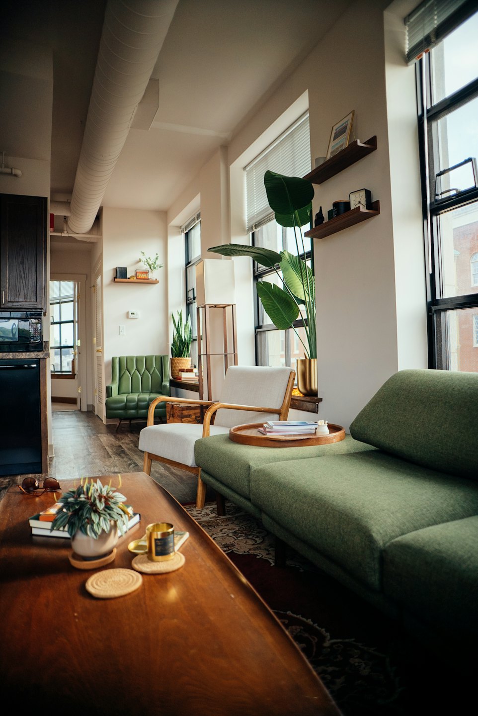 Modernes Wohnzimmer mit grüner Couch und Pflanzen.
